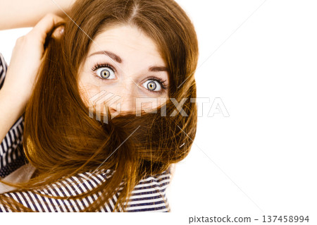 Woman having face covered with her brown hair Woman having face covered with her brown hair 137458994