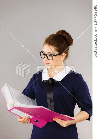 Focused business woman writing something down Focused business woman writing something down 137458996