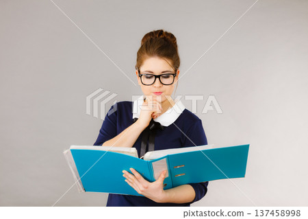 woman thinking holds file folder with documents 137458998