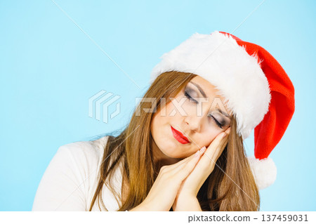 Woman in santa hat being sleepy Woman in santa hat being sleepy 137459031