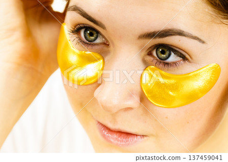 Woman with gold patches under eyes Woman with gold patches under eyes 137459041