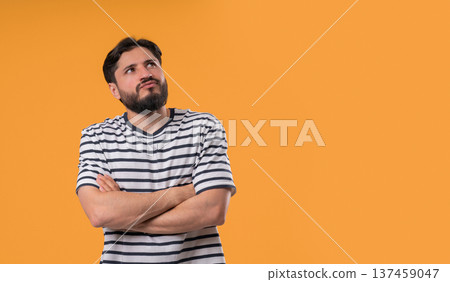 Thinking man looking up, searching opportunity on yellow background. Curious pensive man considering 137459047