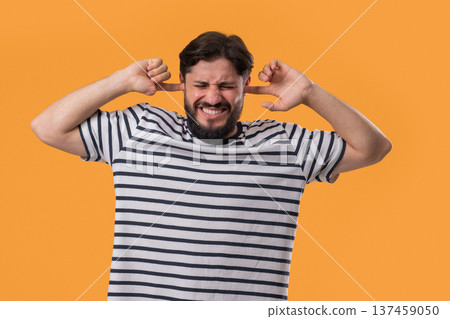 Annoyed Man With Shut Ears On Yellow. Guy Block Annoying Sounds, Loud Music 137459050