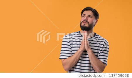 Bearded Man Praying With Fingers On Yellow, Copy space. Guy Begs Satisfy Desires 137459068