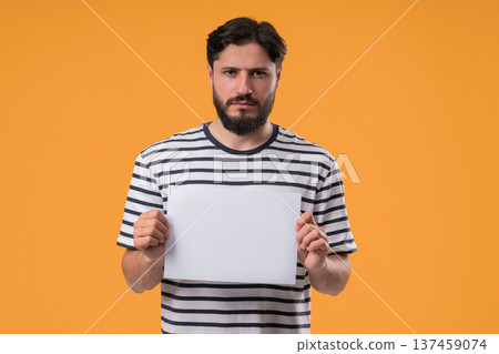 Serious man Holding Horizontal White A4 Paper Poster. Copy Space. Mock-Up Banner Serious man Holding Horizontal White A4 Paper Poster. Copy Space. Mock-Up Banner 137459074