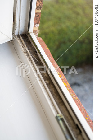 Dirty plastic window. Dust-covered plastic window frame and sill with dirt buildup and stains. Spring home cleaning concept Dirty plastic window. Dust-covered plastic window frame and sill with dirt buildup and stains. Spring home cleaning concept 137459081