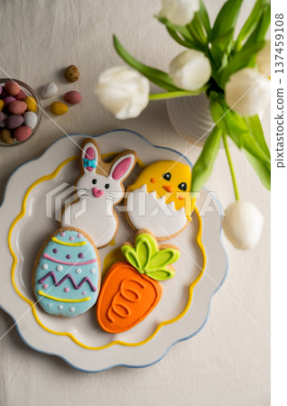 Easter festive colourful cookies bunny, carrot, egg, chick in a plate with egg candies and bouquet of spring tulips Easter festive colourful cookies bunny, carrot, egg, chick in a plate with egg candies and bouquet of spring tulips 137459108