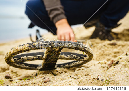 Man with metal detector on sea beach 137459116