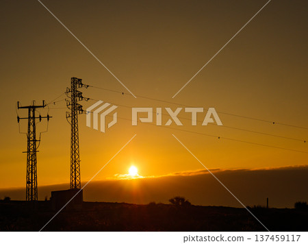 High voltage towers on coast at sunset 137459117