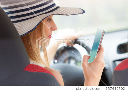 Woman using phone while driving her car Woman using phone while driving her car 137459502