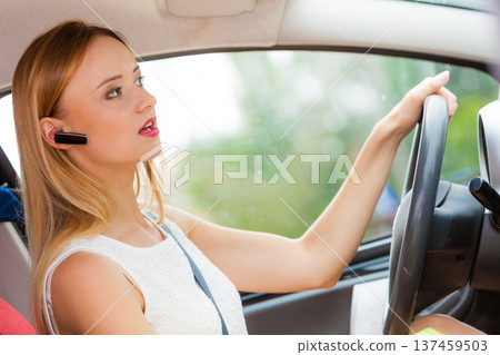 woman driving car with headset woman driving car with headset 137459503
