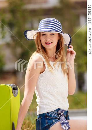 Attractive woman tourist with suitcase relaxing after trip Attractive woman tourist with suitcase relaxing after trip 137459512