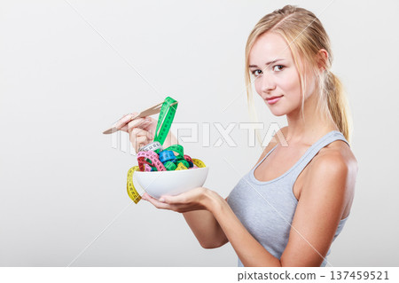 Diet. Girl with colorful measuring tapes in bowl Diet. Girl with colorful measuring tapes in bowl 137459521