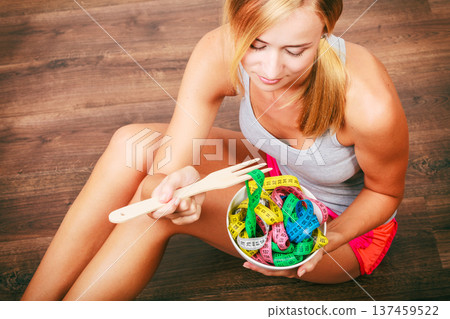 Diet. Girl with colorful measuring tapes in bowl Diet. Girl with colorful measuring tapes in bowl 137459522