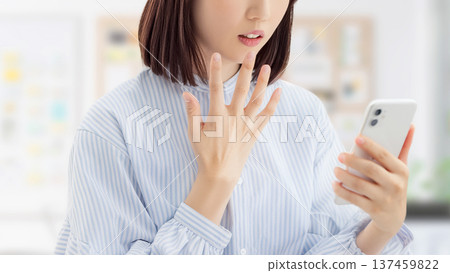 一位女士/女商人對她的智慧型手機螢幕感到驚訝 一位女士/女商人對她的智慧型手機螢幕感到驚訝 137459822