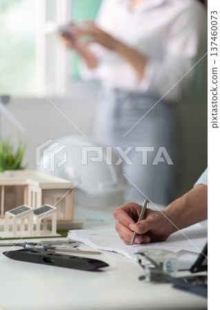 A man is writing on a piece of paper with a pen A man is writing on a piece of paper with a pen 137460073