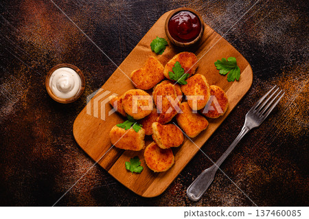 Fried crispy chicken nuggets on a wooden serving board. 137460085