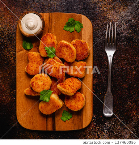 Fried crispy chicken nuggets on a wooden serving board. Fried crispy chicken nuggets on a wooden serving board. 137460086