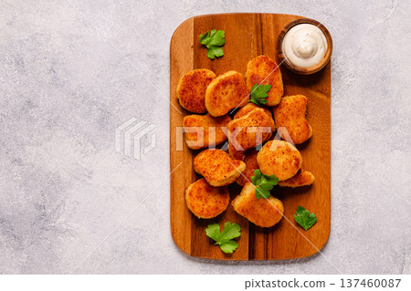 Fried crispy chicken nuggets on a wooden serving board. 137460087