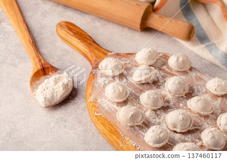 Homemade raw dumplings on the board. Homemade raw dumplings on the board. 137460117