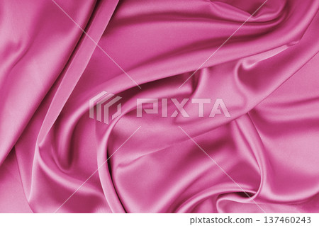 Crumpled, wrinkled pink colored glossy silk satin texture. Shiny fabric cloth with wave folds 137460243