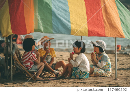 孩子們在沙灘上的遮陽傘下排隊喝果汁 137460292