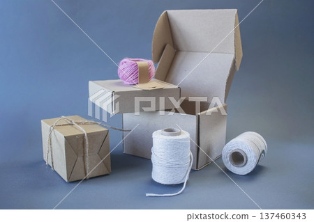 Cardboard boxes and packing twine, delivery concept. Stacking of postal cardboard boxes and packing twine. Cardboard boxes and packing twine, delivery concept. Stacking of postal cardboard boxes and packing twine. 137460343