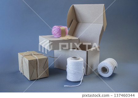Cardboard boxes and packing twine, delivery concept. Stacking of postal cardboard boxes and packing twine. Cardboard boxes and packing twine, delivery concept. Stacking of postal cardboard boxes and packing twine. 137460344
