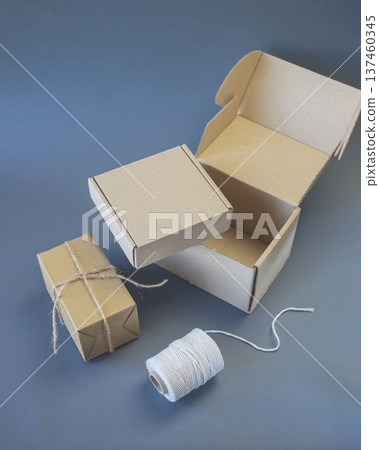 Cardboard boxes and packing twine, delivery concept. Stacking of postal cardboard boxes and packing twine. Cardboard boxes and packing twine, delivery concept. Stacking of postal cardboard boxes and packing twine. 137460345