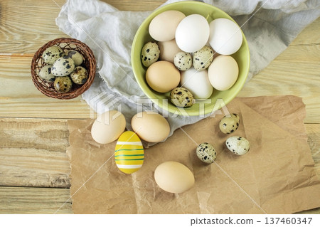 Easter, preparation for the holiday. Various colored and fresh chicken and quail eggs on a rustic wooden table. Easter, preparation for the holiday. Various colored and fresh chicken and quail eggs on a rustic wooden table. 137460347