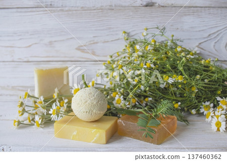Natural handmade soap with chamomile and bath bomb. Natural handmade soap and chamomile flowers on a white wooden background. Natural handmade soap with chamomile and bath bomb. Natural handmade soap and chamomile flowers on a white wooden background. 137460362