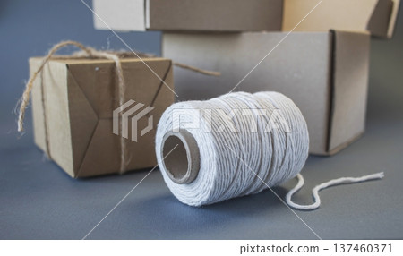 Cardboard boxes and packing twine, delivery concept. Stacking of postal cardboard boxes and packing twine. Cardboard boxes and packing twine, delivery concept. Stacking of postal cardboard boxes and packing twine. 137460371