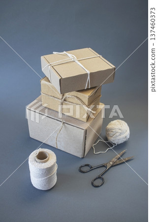 Cardboard boxes and packing twine, delivery concept. Stacking of postal cardboard boxes and packing twine. Cardboard boxes and packing twine, delivery concept. Stacking of postal cardboard boxes and packing twine. 137460373