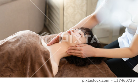 A woman receiving beauty treatment and massage A woman receiving beauty treatment and massage 137460729