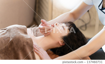 A woman receiving beauty treatment and massage A woman receiving beauty treatment and massage 137460731