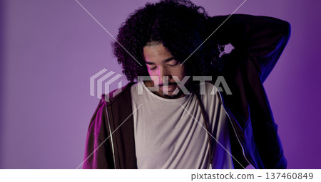Young latin dancer posing with purple and blue lights, holding his head Young latin dancer posing with purple and blue lights, holding his head 137460849