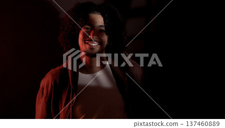 Young african-american man smiling wearing casual clothes under red light 137460889