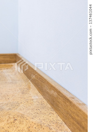 wooden baseboard on new wood cork tiles on floor 137461044