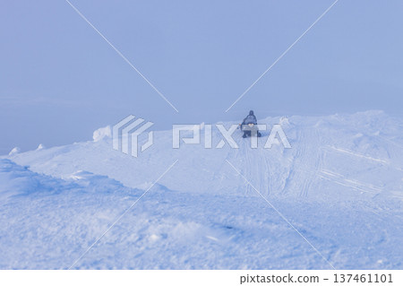 snowmobile at snow-covered slope, foggy winter day 137461101
