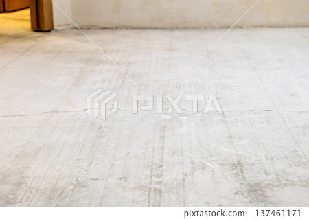 concrete screed in room with stripped flooring 137461171