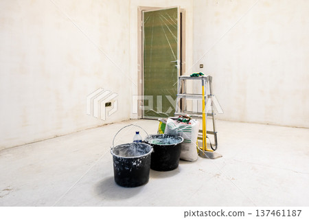 plasterer's equipment in room with rough finishing plasterer's equipment in room with rough finishing 137461187
