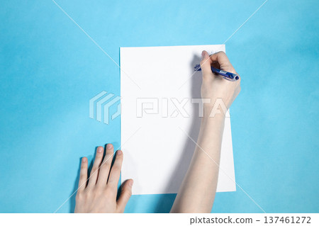 above view of hand writes on blank white paper 137461272