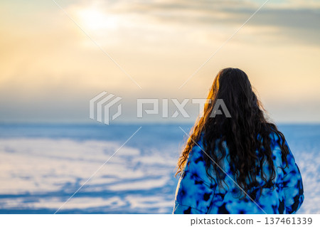 tourist looks on frozen bay on winter sunrise tourist looks on frozen bay on winter sunrise 137461339