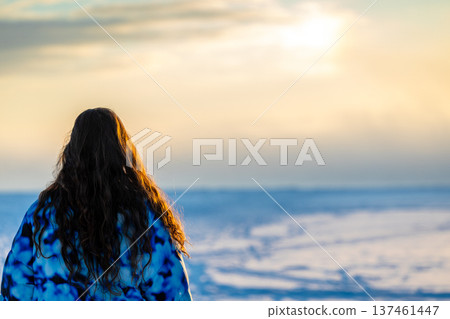 tourist looks on sun over frozen Kandalaksha bay tourist looks on sun over frozen Kandalaksha bay 137461447