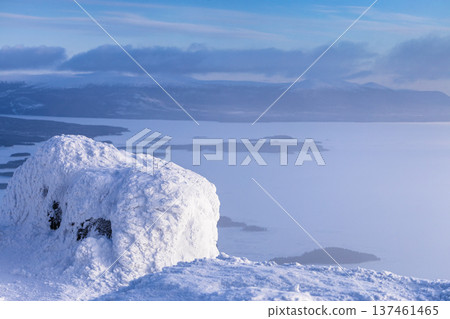 snowbound rock and view of Kandalaksha bay in haze snowbound rock and view of Kandalaksha bay in haze 137461465
