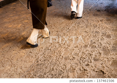 people walk on dirty melting snow on street tiles 137461506