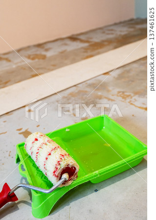 roller lies on tray for gluing cork flooring 137461625