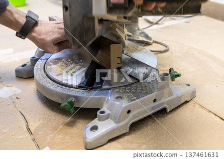 carpenter trims baseboard on portable circular saw carpenter trims baseboard on portable circular saw 137461631