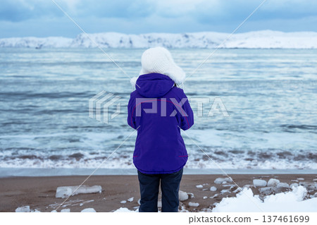 wooman looks on Barents Sea in Teriberka, winter 137461699
