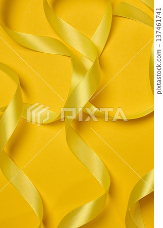 Yellow satin ribbons scattered chaotically, curves and loops, yellow background. Yellow satin ribbons scattered chaotically, curves and loops, yellow background. 137461741